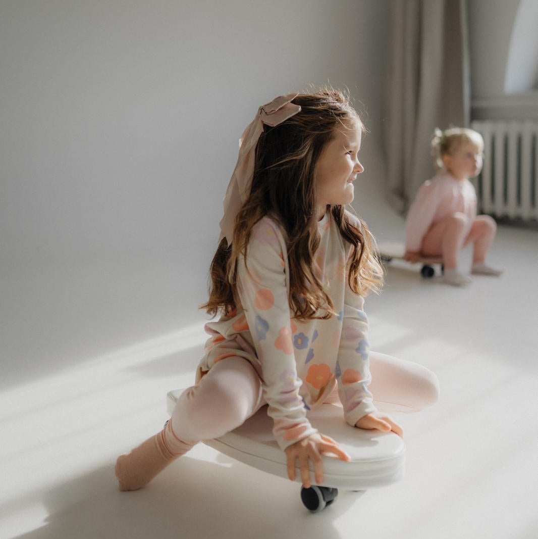 Two young girls playing on a soft toy rider. 